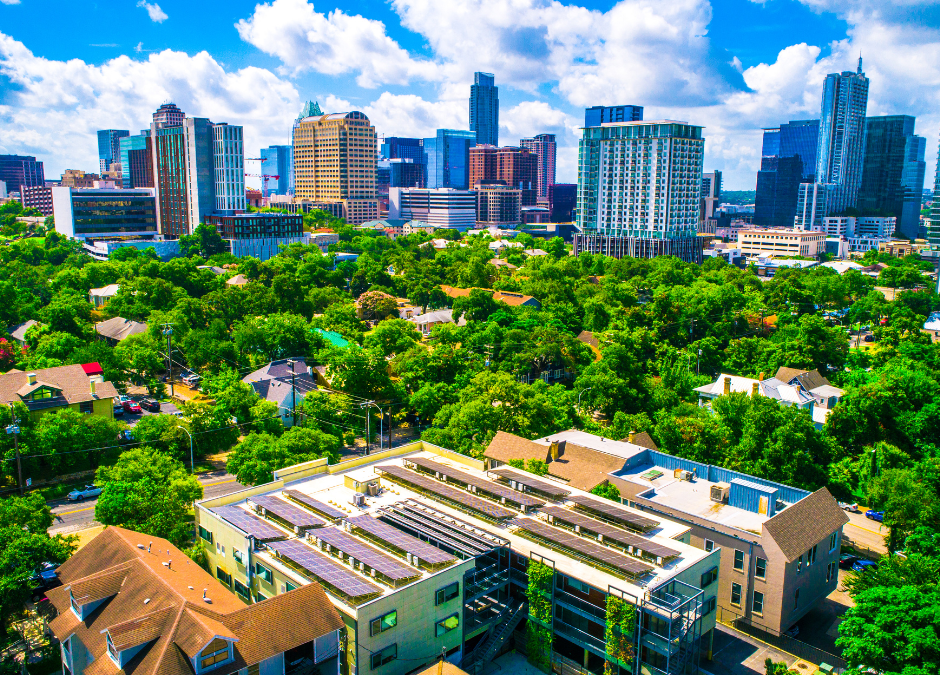 Solar panels on apartments with Austin skyline in background.