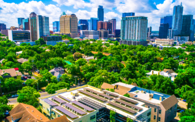 Solar panels on apartments with Austin skyline in background.